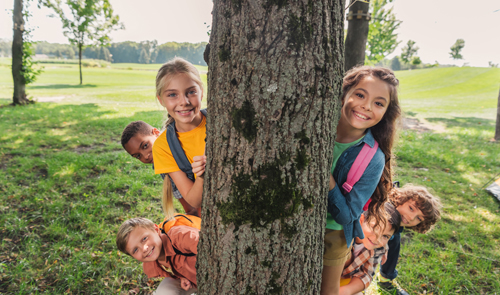 Enfants jouant derrière un arbre